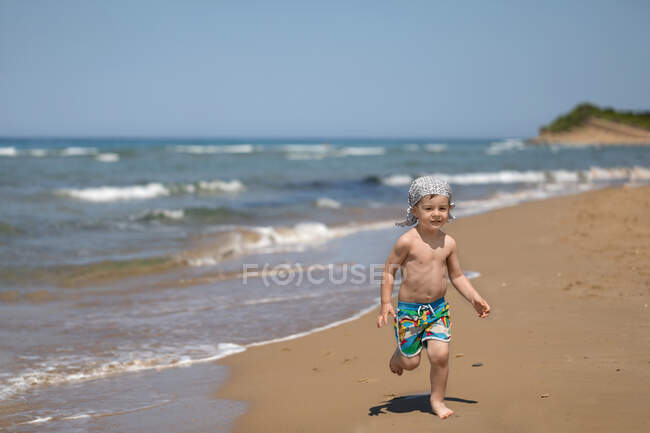 Menino correndo na praia, Corfu, Grécia — Fotografia de Stock