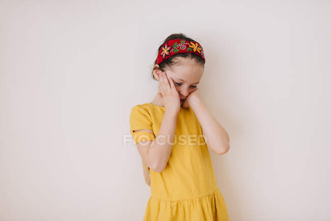 Ritratto di una ragazza stanca che si sfrega il viso su sfondo bianco — Foto stock