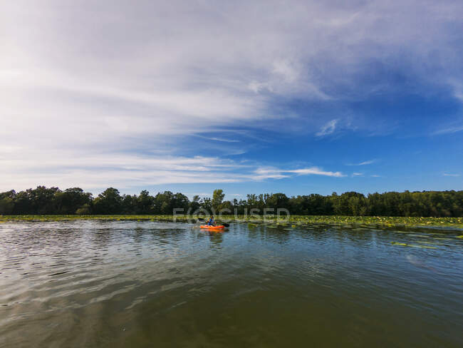 Vista a distanza di ragazzo kayak nel lago — Foto stock