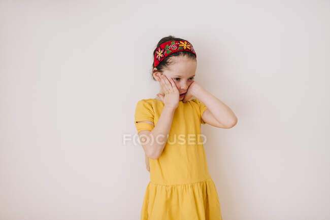 Retrato de uma menina com uma dor de cabeça no fundo branco — Fotografia de Stock