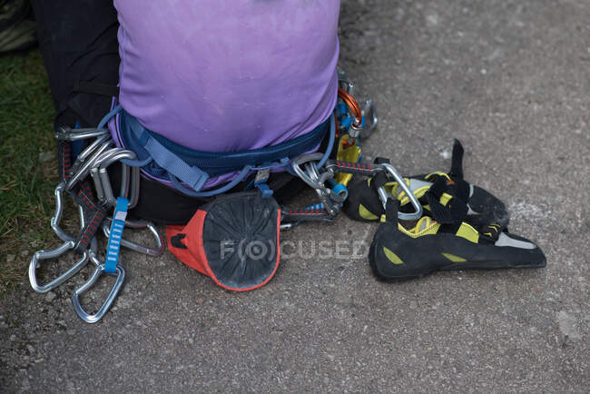 Man sitting on ground wearing a rock climbing harness — Stock Photo
