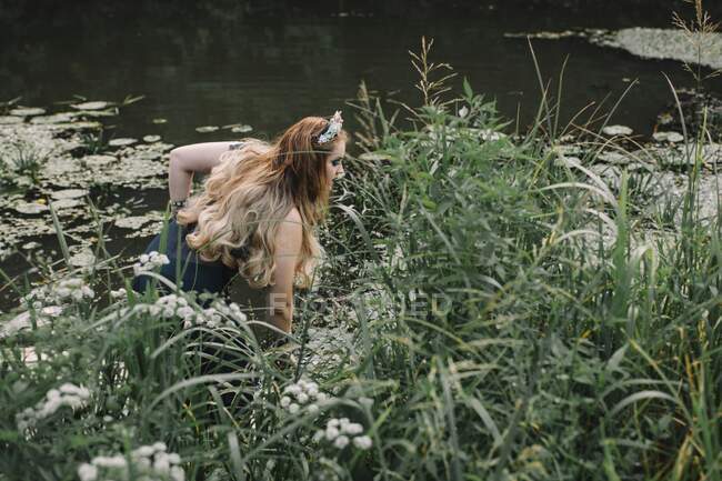 Mujer boho saliendo de un lago, Rusia - foto de stock