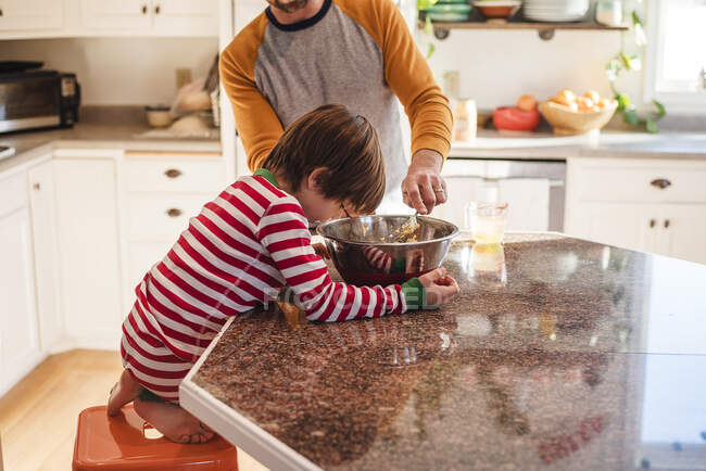 Мальчик помогает отцу печь на кухне. — стоковое фото
