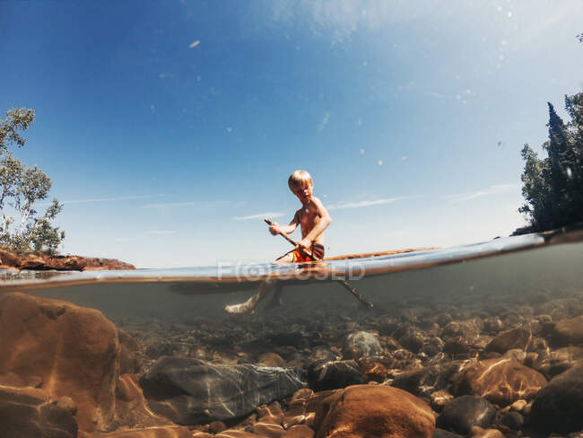 Boy sailing on a lake on a wooden raft, Lake Superior, United States — Stock Photo