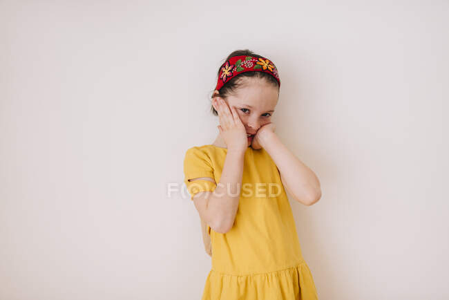 Portrait d'une fille souriante avec les mains sur le visage — Photo de stock