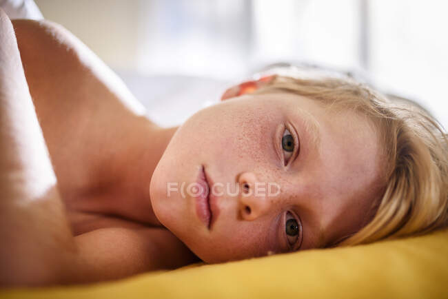 Portrait of a boy in bed waking up — Stock Photo