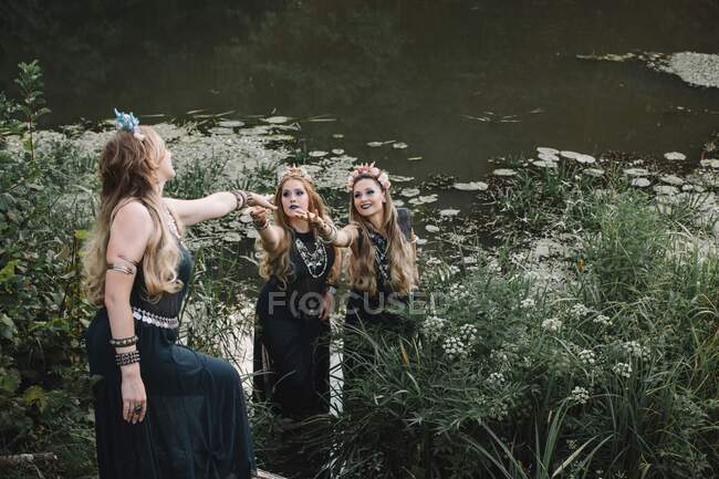 Tres mujeres boho de pie en un lago, Rusia - foto de stock