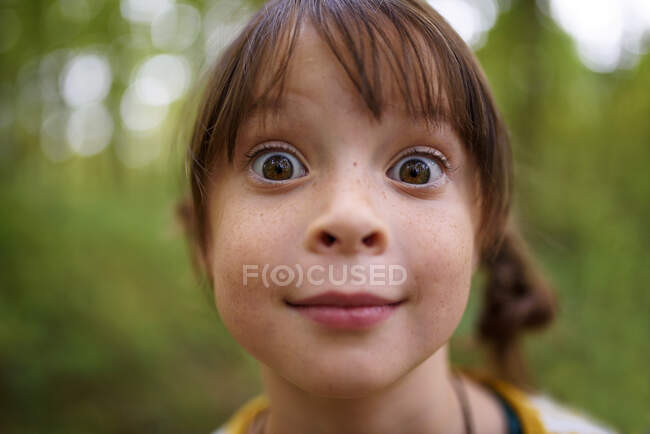 Retrato de una chica de ojos anchos parada al aire libre, Estados Unidos - foto de stock