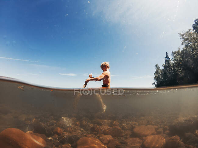 Boy sailing on a lake on a wooden raft, Lake Superior, United States — Stock Photo