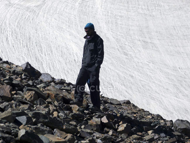 Uomo in piedi su massi rocciosi, Kangyatse Advanced Base Camp, Himalaya, India — Foto stock