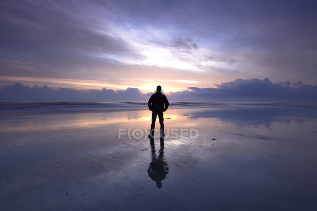 Silhouette dell'uomo in piedi sulla spiaggia al tramonto, Malesia — Foto stock