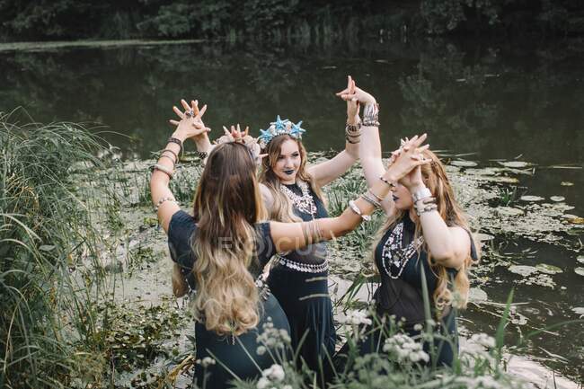 Three boho women dancing in a lake, Russia — Stock Photo