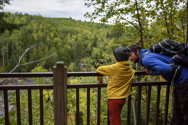 Vater und Sohn stehen auf einer Brücke mit Blick auf den Lake Superior Provincial Park, Vereinigte Staaten — Stockfoto