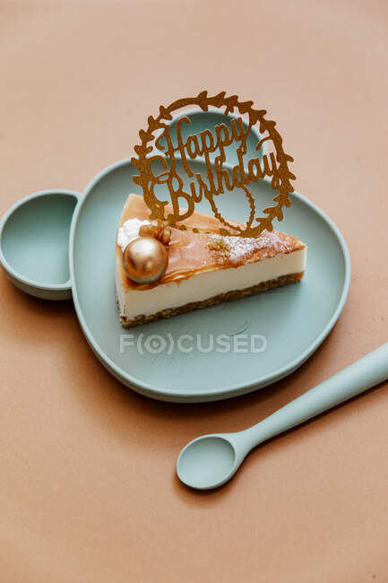 Slice of chocolate birthday cake on a baby's plastic bear shaped plate — Stock Photo