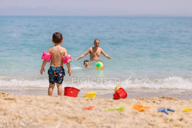 Отец и двое сыновей на пляже, Греция — стоковое фото