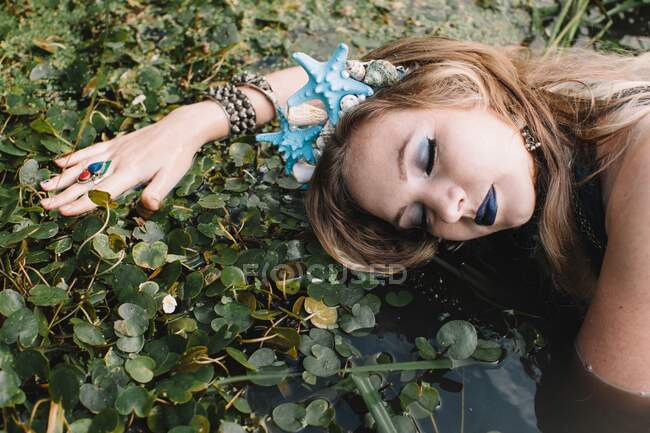 Portrait of a boho woman lying in lake, Russia — Stock Photo