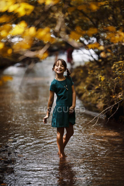 Souriante fille marchant dans un ruisseau boisé, États-Unis — Photo de stock