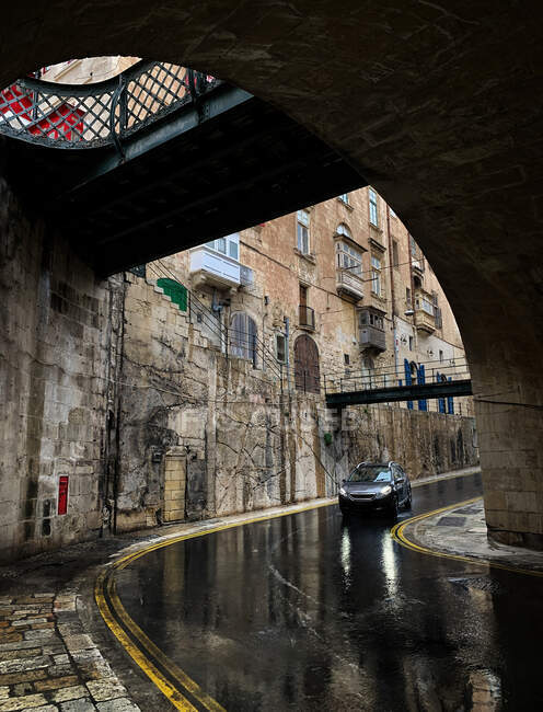Voiture conduite à travers la ville sous la pluie, La Valette, Malte — Photo de stock