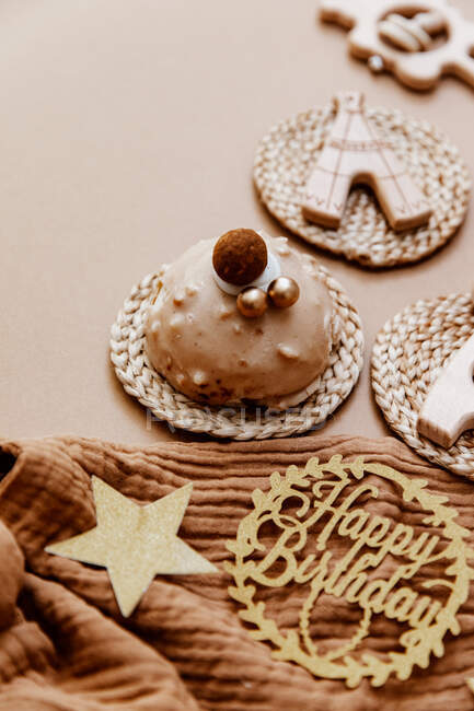 Close-up de um bolo de aniversário de chocolate cercado por brinquedos e acessórios do bebê — Fotografia de Stock