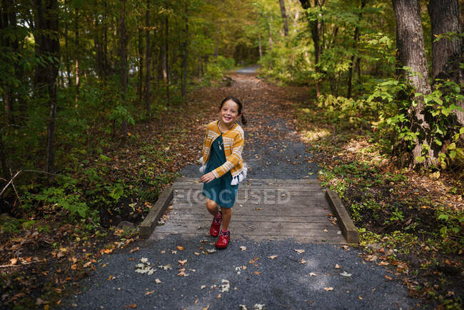 Girl running across a small footbridge, États-Unis — Photo de stock