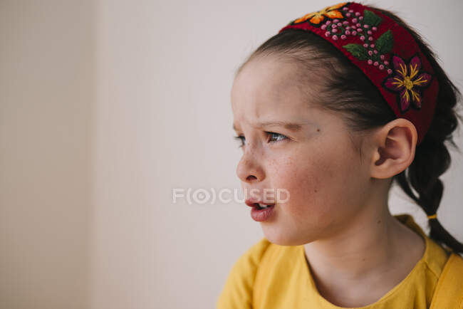 Портрет эмоциональной маленькой девочки на фоне белой стены — стоковое фото
