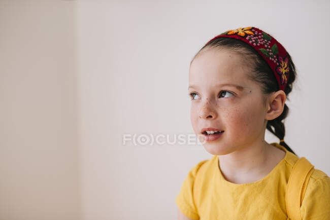 Portrait de petite fille émotionnelle sur fond de mur blanc — Photo de stock