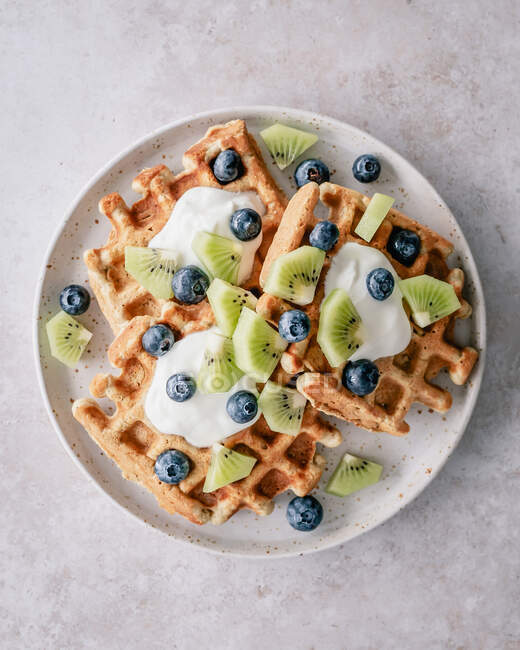 Waffles with yoghurt, blueberries and kiwi fruit — Stock Photo