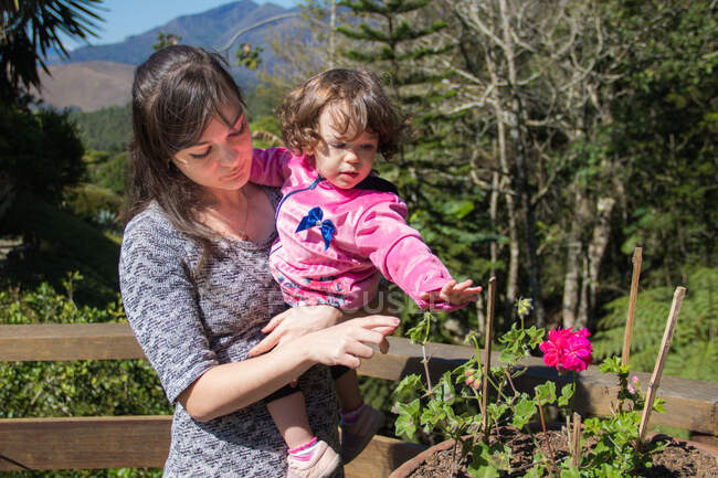 Mother standing in a garden with her daughter, Brazil — Stock Photo