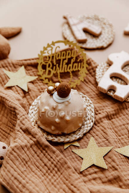 Close-up de um bolo de aniversário de chocolate cercado por brinquedos e acessórios do bebê — Fotografia de Stock