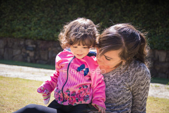 Mother and daughter sitting in a public park — Stock Photo