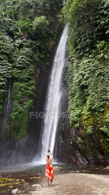 Mulher tirando uma foto da cachoeira Munduk, Bali, Indonésia. — Fotografia de Stock
