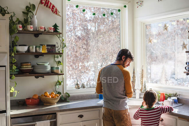 Padre e figlio in piedi in cucina a lavare — Foto stock