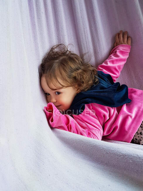 Sorrindo menina deitada em uma rede — Fotografia de Stock