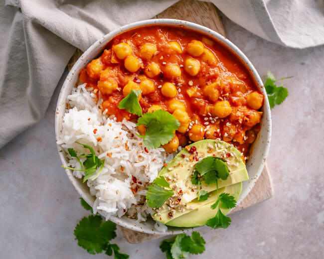 Chickpea stew, rice and avocado with chilli flakes and fresh coriander — Stock Photo