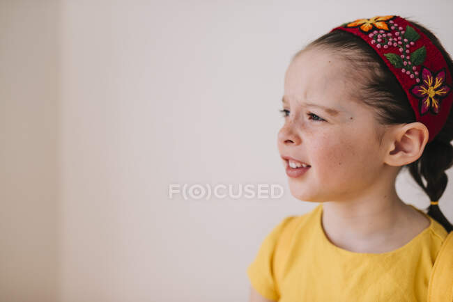 Портрет емоційної дівчинки на фоні білої стіни — стокове фото