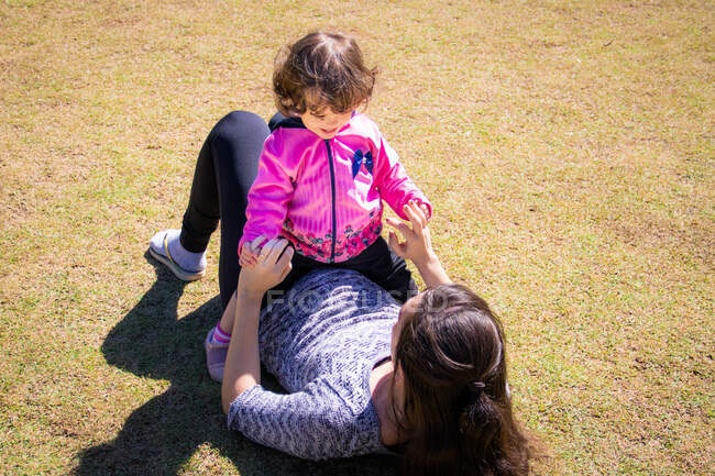 Portrait of a mother and daughter sitting in a public park — Stock Photo