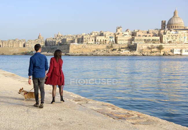 Paar spaziert mit Hund am Wasser entlang, Valletta, Malta — Stockfoto