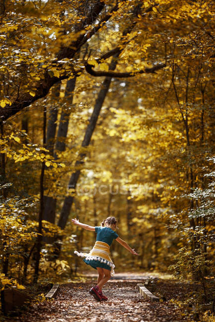 Girl standing on a small footbridge dancing, États-Unis — Photo de stock