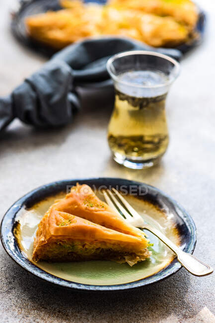 Gros plan d'une tranche de baklava avec un verre de thé — Photo de stock