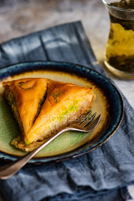 Close-up of a slice of baklava with a glass of tea — Stock Photo