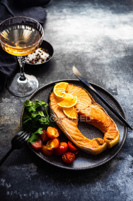 Steak de saumon grillé aux tomates, citron et un verre de vin blanc — Photo de stock