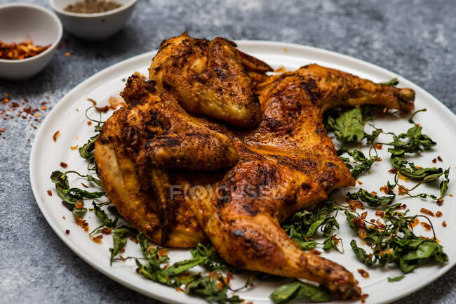 Georgian pan fried chicken tabaka with fried coriander leaves and chilli flakes — Stock Photo