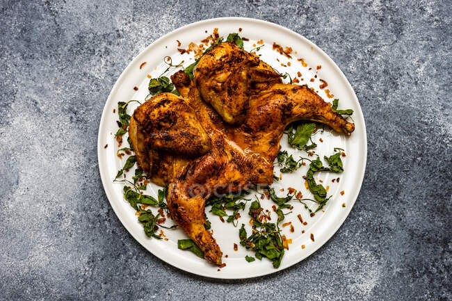 Georgian pan fried chicken tabaka with fried coriander leaves and chilli flakes — Stock Photo
