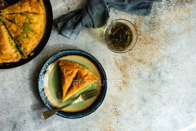 Overhead view of a slice of baklava with a glass of tea — Stock Photo