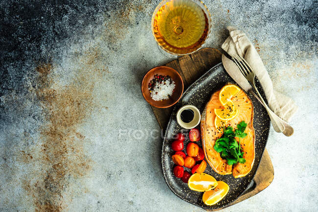 Стейк на грилі з помідорами, лимоном та склянкою білого вина — стокове фото