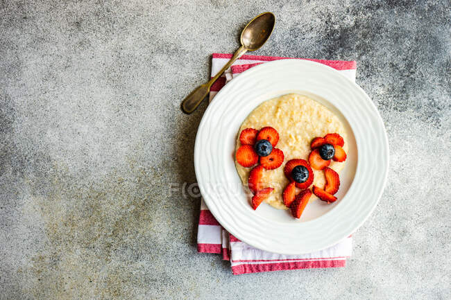 Ciotola di porridge decorato con frutta per assomigliare a fiori — Foto stock