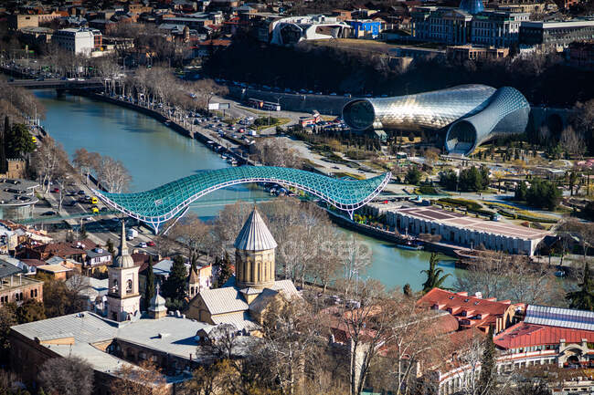 Paisaje urbano aéreo con Puente de la Paz a través del puente de Mtkvari, Tiflis, Georgia - foto de stock