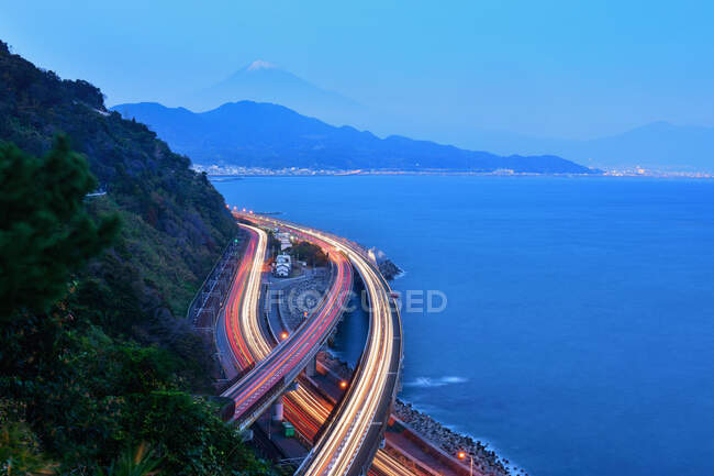 Camino de la orilla del lago con senderos ligeros y el Monte Fuji en la distancia, Yamanashi, Honshu, Japón - foto de stock