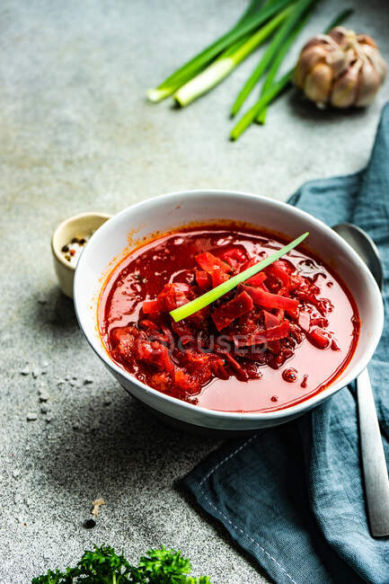 Bowl of beetroot soup with spring onion garnish — Stock Photo