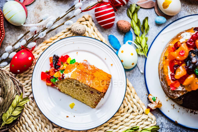 Fatia de bolo de Easter com glace fruit em uma mesa com decorações de Easter — Fotografia de Stock
